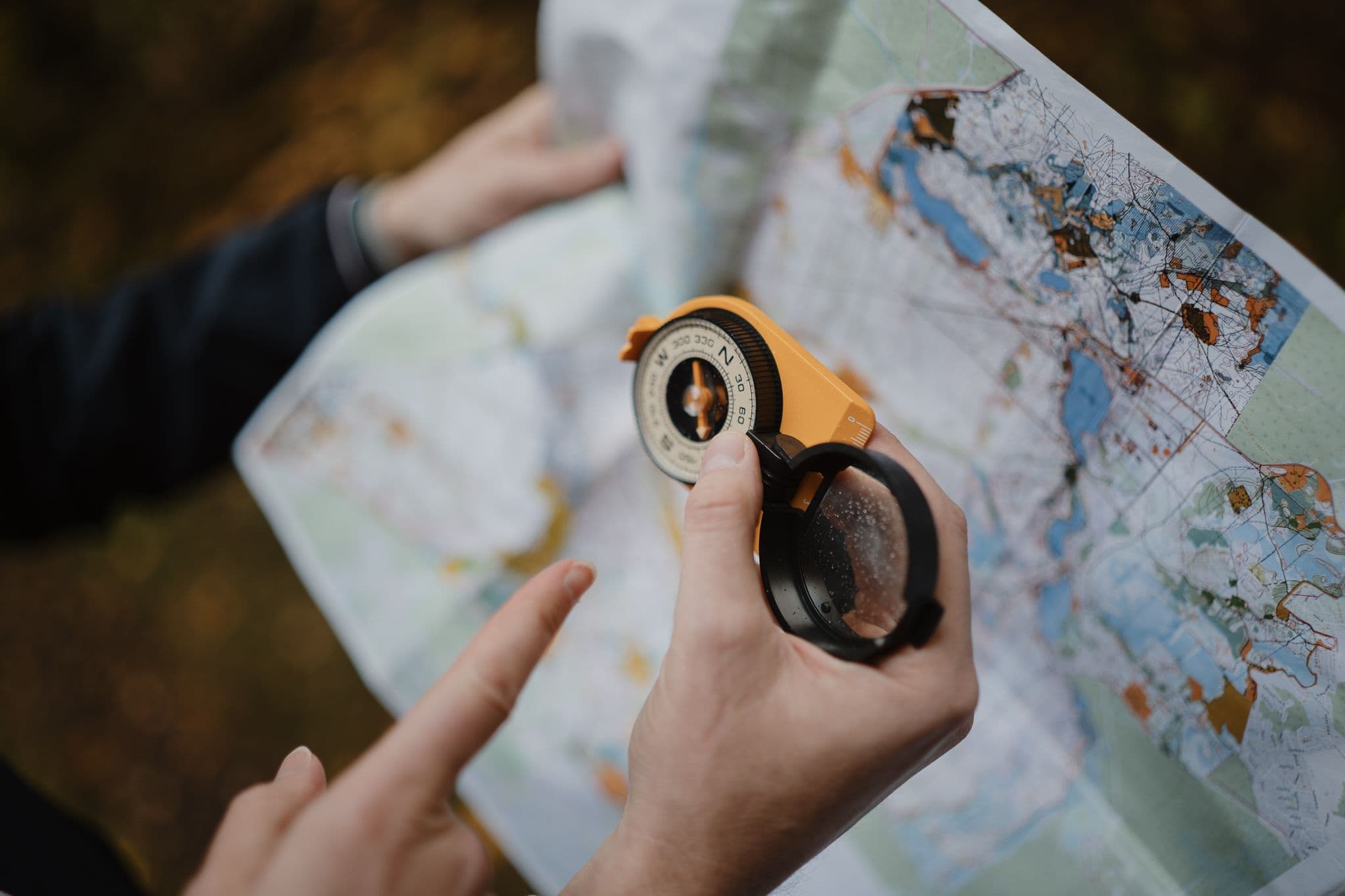 Rankoje laikomas kompasas, kurio pagalba skaitomas žemėlapis