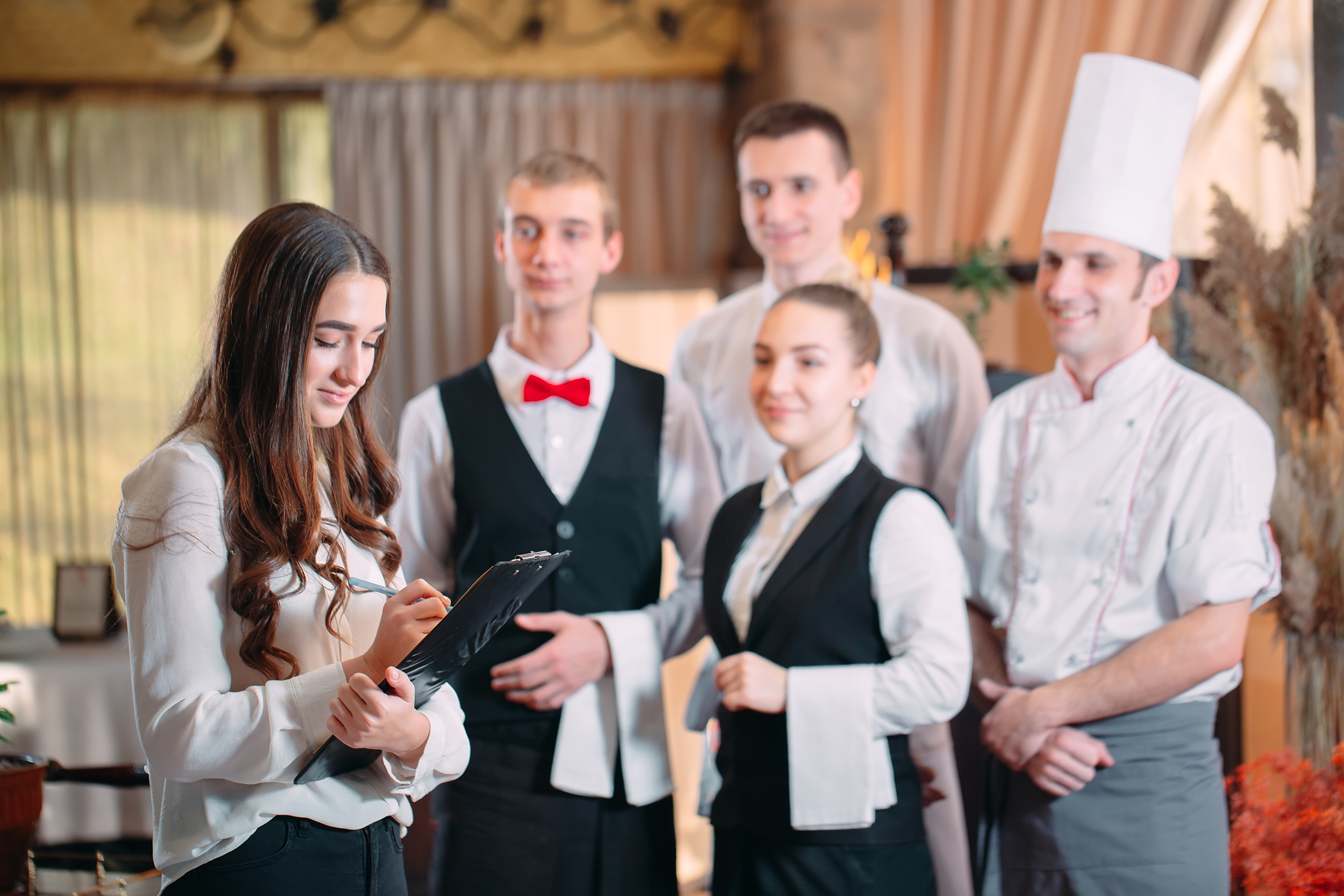 restaurant manager and his staff in kitchen. interacting to head chef in commercial kitchen